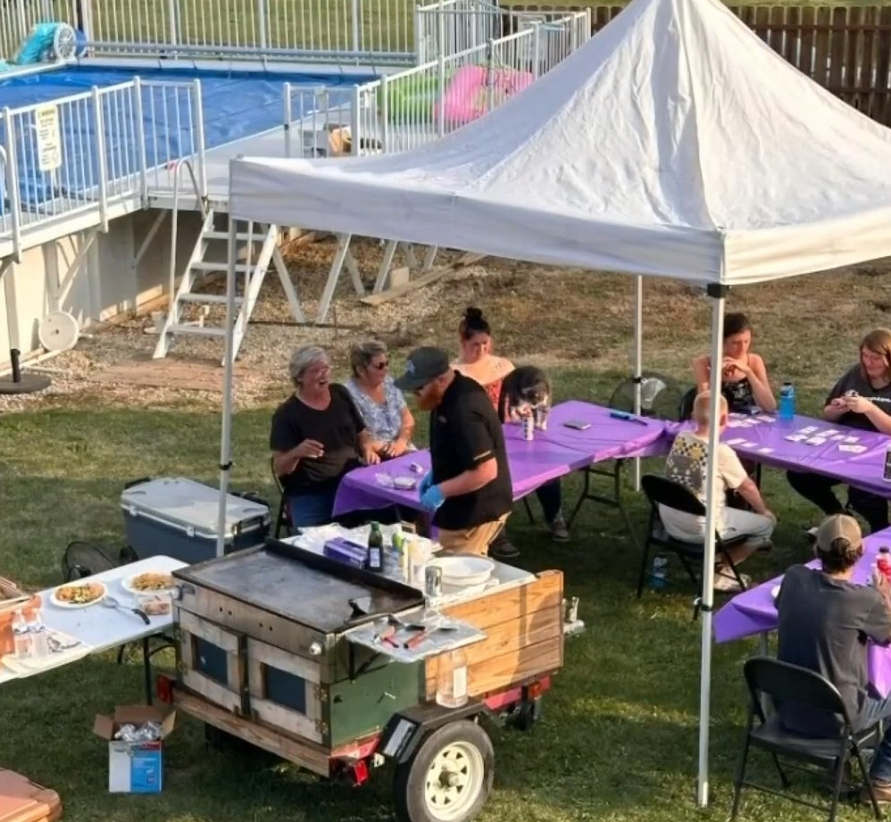 Backyard hibachi party with guests under a tent